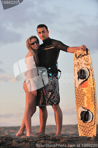 Image of surf couple posing at beach on sunset