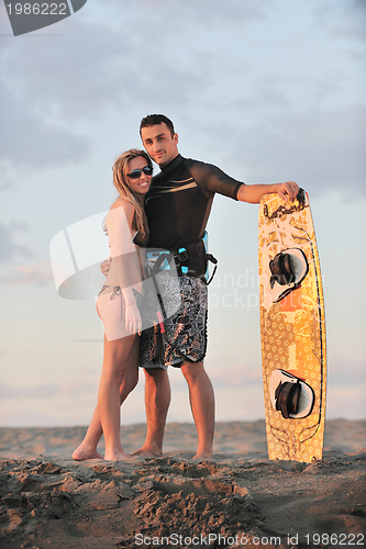 Image of surf couple posing at beach on sunset