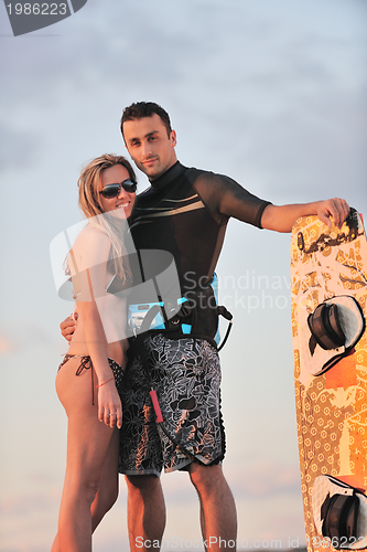 Image of surf couple posing at beach on sunset