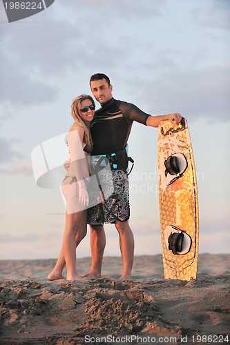 Image of surf couple posing at beach on sunset