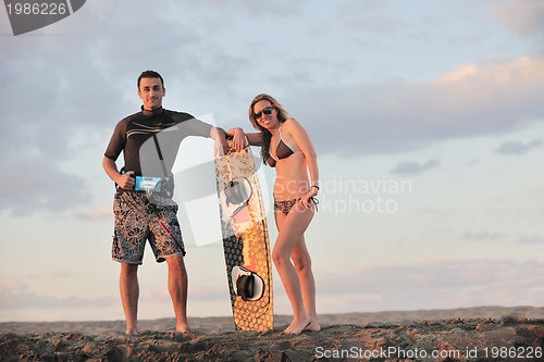 Image of surf couple posing at beach on sunset