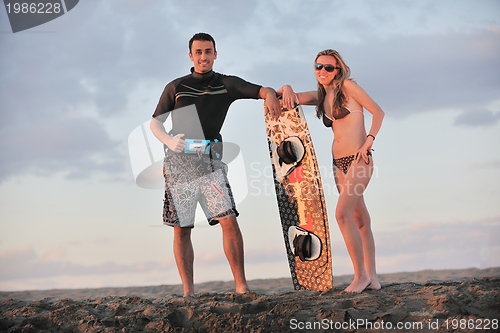 Image of surf couple posing at beach on sunset