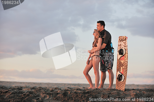 Image of surf couple posing at beach on sunset