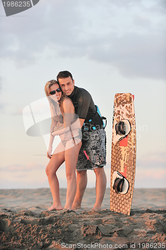 Image of surf couple posing at beach on sunset