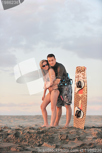 Image of surf couple posing at beach on sunset