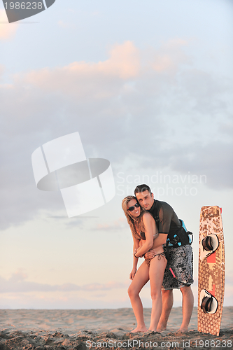 Image of surf couple posing at beach on sunset