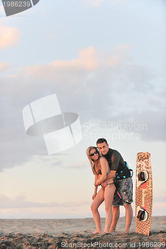 Image of surf couple posing at beach on sunset
