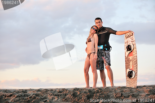 Image of surf couple posing at beach on sunset