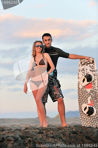 Image of surf couple posing at beach on sunset