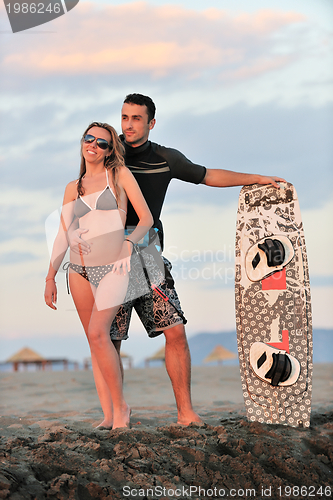 Image of surf couple posing at beach on sunset