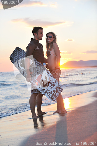 Image of surf couple posing at beach on sunset