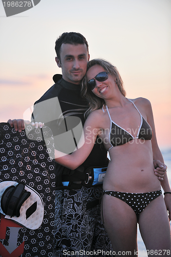 Image of surf couple posing at beach on sunset