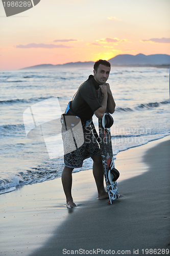 Image of Portrait of a young  kitsurf  man at beach on sunset