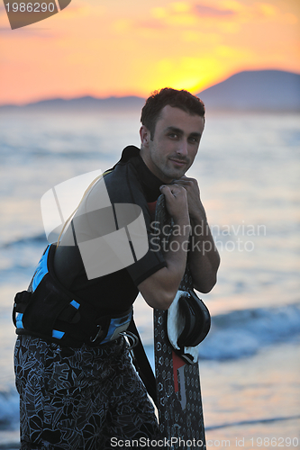Image of Portrait of a young  kitsurf  man at beach on sunset