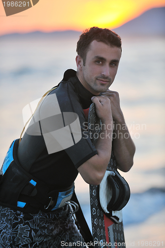 Image of Portrait of a young  kitsurf  man at beach on sunset