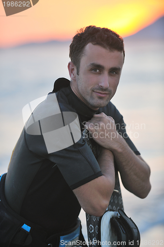 Image of Portrait of a young  kitsurf  man at beach on sunset