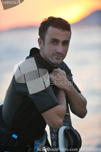 Image of Portrait of a young  kitsurf  man at beach on sunset