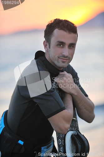Image of Portrait of a young  kitsurf  man at beach on sunset