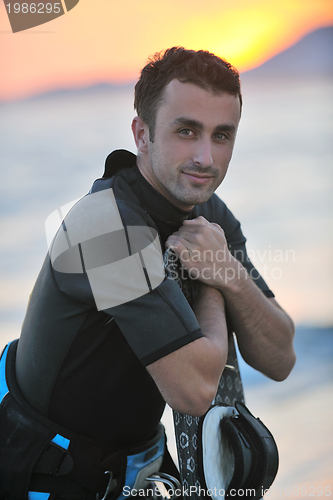 Image of Portrait of a young  kitsurf  man at beach on sunset