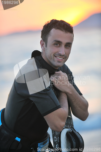 Image of Portrait of a young  kitsurf  man at beach on sunset