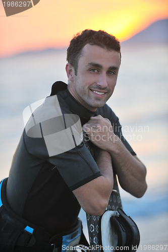 Image of Portrait of a young  kitsurf  man at beach on sunset