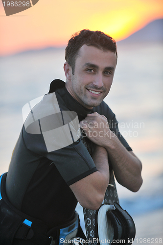 Image of Portrait of a young  kitsurf  man at beach on sunset
