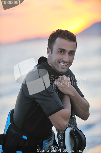 Image of Portrait of a young  kitsurf  man at beach on sunset