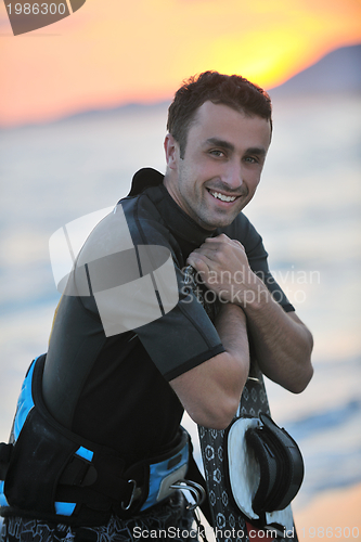 Image of Portrait of a young  kitsurf  man at beach on sunset