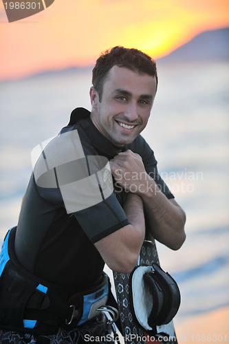 Image of Portrait of a young  kitsurf  man at beach on sunset