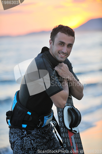 Image of Portrait of a young  kitsurf  man at beach on sunset