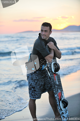 Image of Portrait of a young  kitsurf  man at beach on sunset