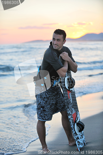 Image of Portrait of a young  kitsurf  man at beach on sunset