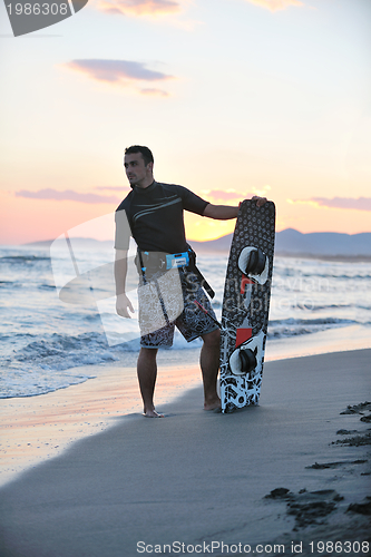 Image of Portrait of a young  kitsurf  man at beach on sunset