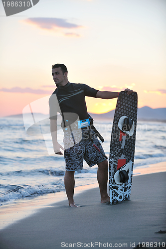 Image of Portrait of a young  kitsurf  man at beach on sunset