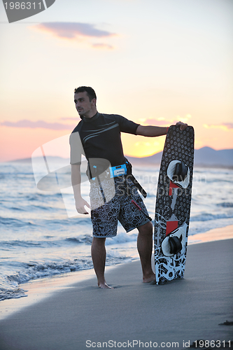 Image of Portrait of a young  kitsurf  man at beach on sunset