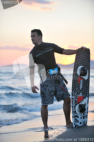 Image of Portrait of a young  kitsurf  man at beach on sunset