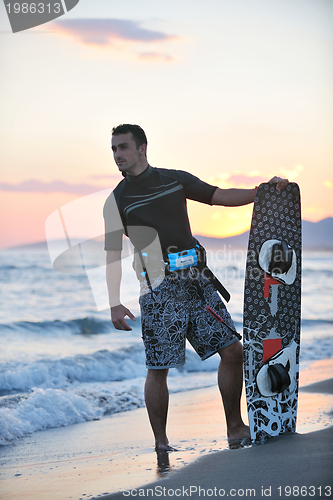 Image of Portrait of a young  kitsurf  man at beach on sunset