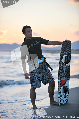 Image of Portrait of a young  kitsurf  man at beach on sunset