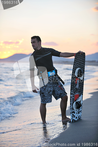 Image of Portrait of a young  kitsurf  man at beach on sunset