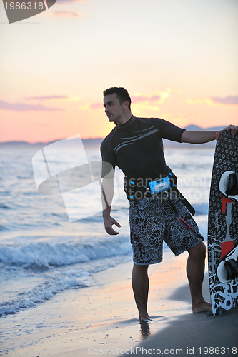 Image of Portrait of a young  kitsurf  man at beach on sunset