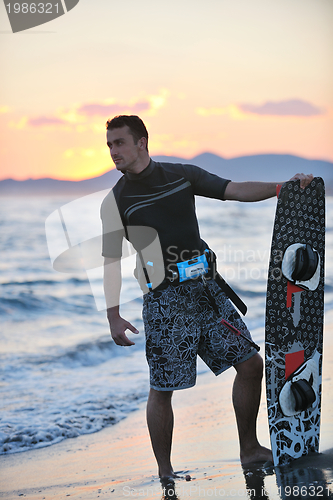 Image of Portrait of a young  kitsurf  man at beach on sunset