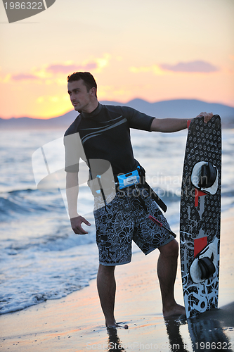 Image of Portrait of a young  kitsurf  man at beach on sunset