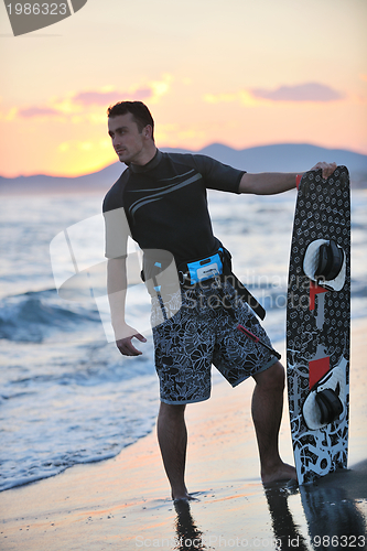 Image of Portrait of a young  kitsurf  man at beach on sunset
