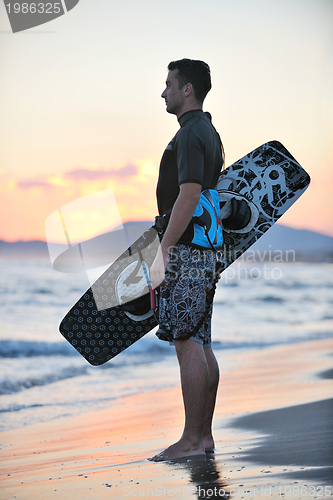 Image of Portrait of a young  kitsurf  man at beach on sunset