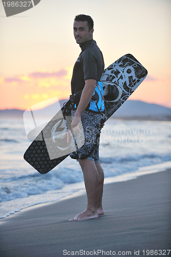 Image of Portrait of a young  kitsurf  man at beach on sunset