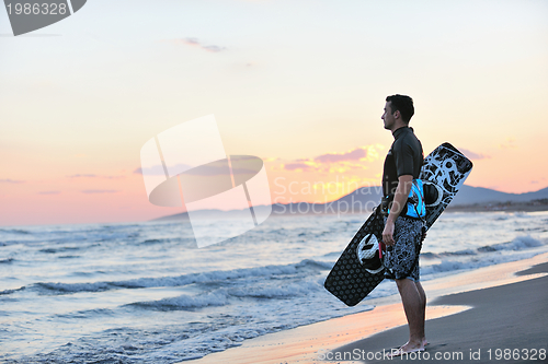 Image of Portrait of a young  kitsurf  man at beach on sunset