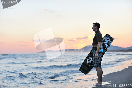 Image of Portrait of a young  kitsurf  man at beach on sunset