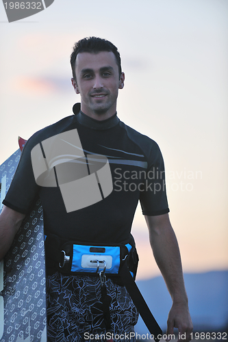 Image of Portrait of a young  kitsurf  man at beach on sunset