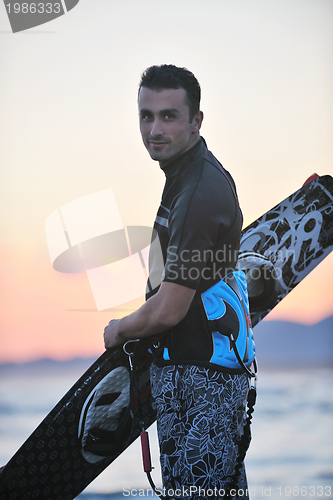 Image of Portrait of a young  kitsurf  man at beach on sunset