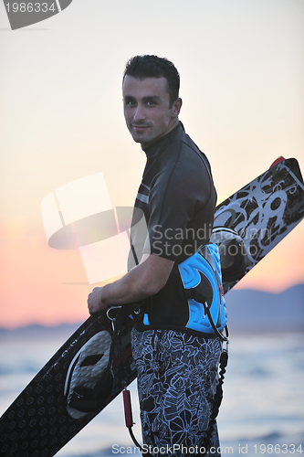 Image of Portrait of a young  kitsurf  man at beach on sunset